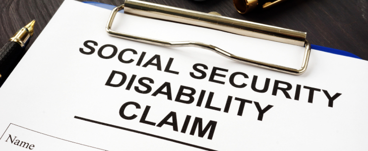 social security disability claim paper on a clipboard on a table with a pen and pen cap denied ssdi