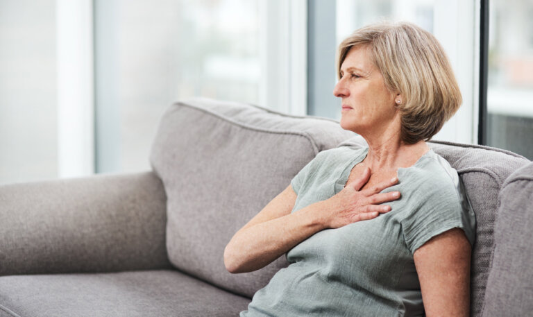 woman holding chest in pain