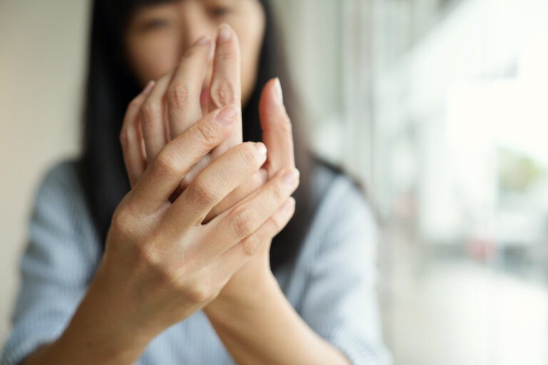 Woman with Rheumatoid Arthritis holding her hand