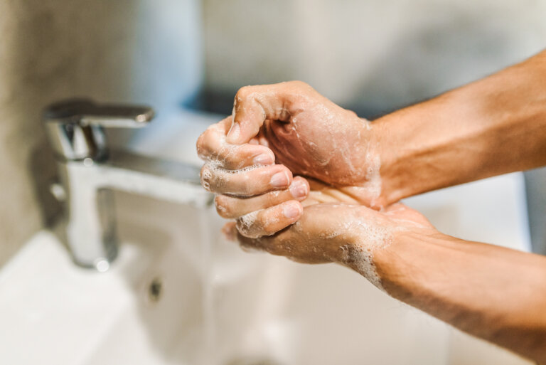 man compulsively washing his hands in sink