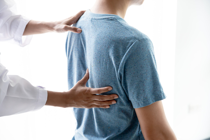 Female doctor and patient back pain after exercise in medical clinic, Pain relief concept.